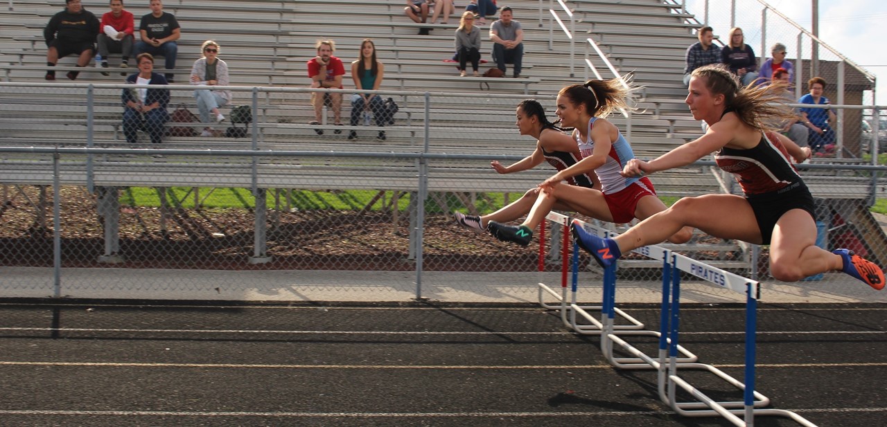 Students jumping hurdles.